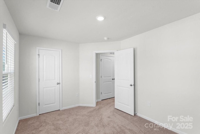 unfurnished bedroom featuring light carpet