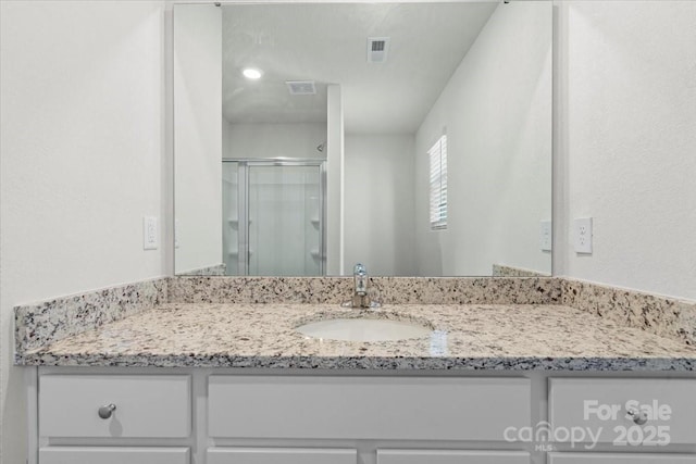 bathroom with vanity and a shower with shower door