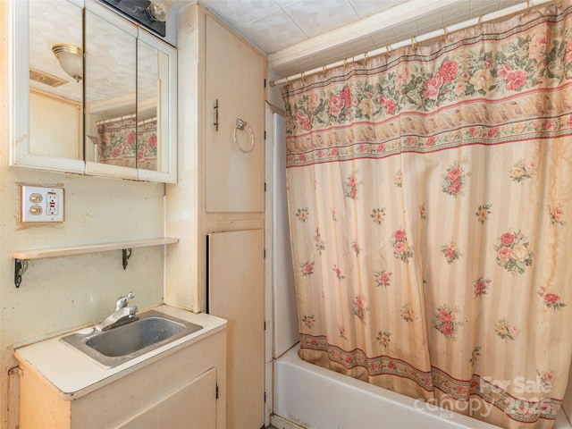 bathroom with shower / bathtub combination with curtain and sink