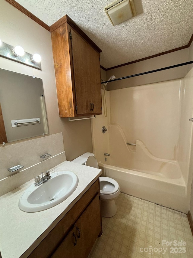 full bathroom with toilet, bathtub / shower combination, a textured ceiling, ornamental molding, and vanity