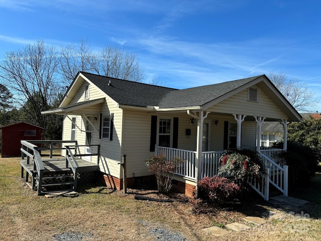 view of front of house with a porch and a storage shed