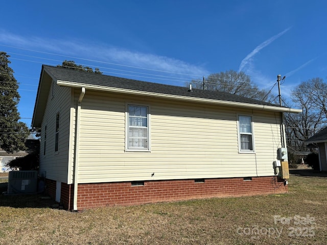 view of side of property with a lawn and central air condition unit