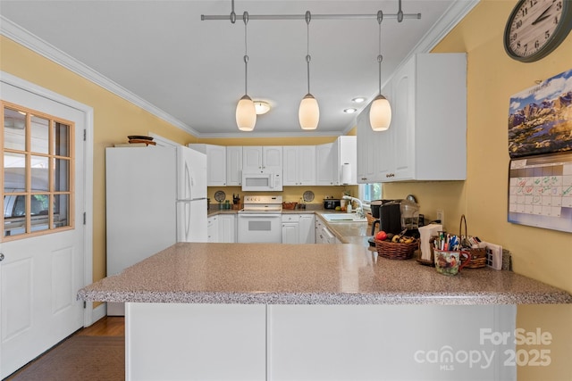 kitchen with decorative light fixtures, white appliances, and kitchen peninsula