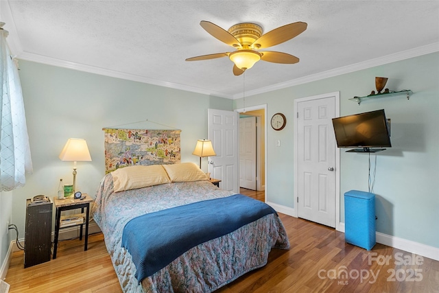 bedroom with hardwood / wood-style flooring, ceiling fan, ornamental molding, and a textured ceiling