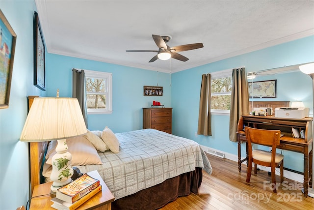 bedroom featuring multiple windows, crown molding, light hardwood / wood-style floors, and ceiling fan