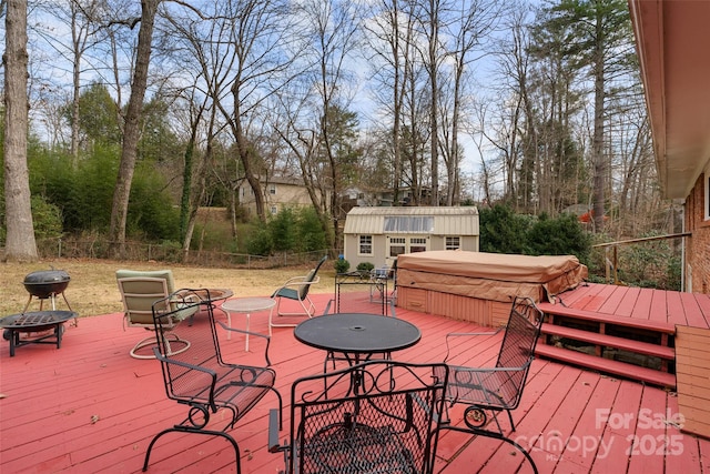 deck featuring an outdoor structure and a covered hot tub