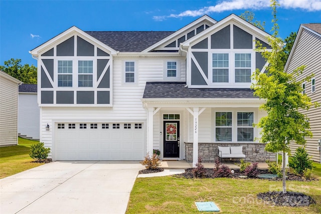 view of front of home featuring a porch, a garage, and a front lawn