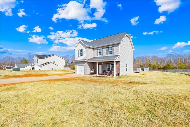 traditional-style home with a garage, brick siding, a front yard, and fence