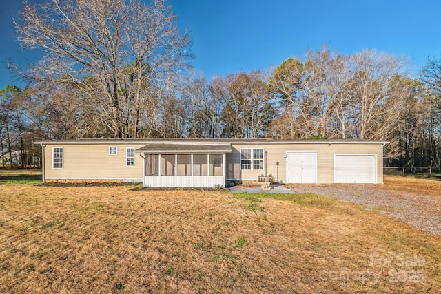 view of front of home with a garage, a sunroom, and a front yard