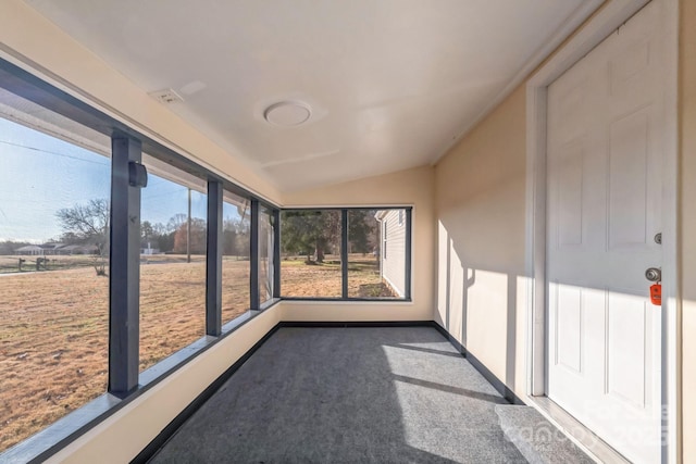 unfurnished sunroom featuring vaulted ceiling