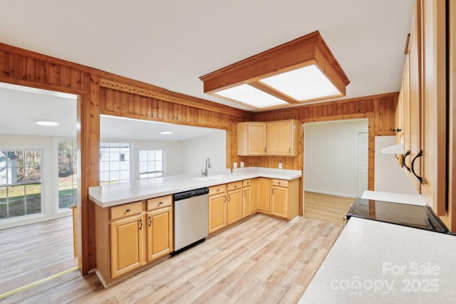 kitchen featuring light brown cabinetry, wood walls, stove, stainless steel dishwasher, and light hardwood / wood-style floors