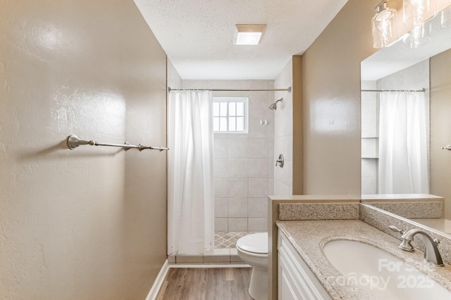 bathroom featuring toilet, a shower with curtain, a textured ceiling, vanity, and hardwood / wood-style floors