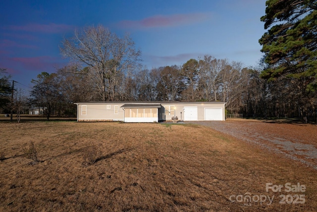 single story home with a garage and a yard