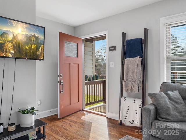 foyer entrance with wood finished floors and baseboards