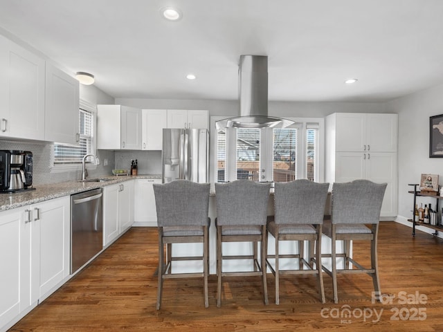 kitchen with white cabinets, island exhaust hood, light stone counters, and stainless steel appliances