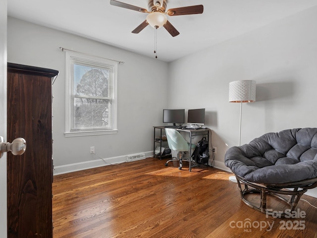 office space featuring visible vents, ceiling fan, baseboards, and wood finished floors