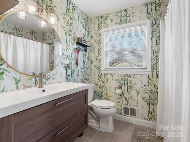 bathroom with baseboards, toilet, and wallpapered walls