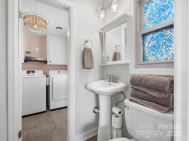 bathroom with visible vents, toilet, and separate washer and dryer