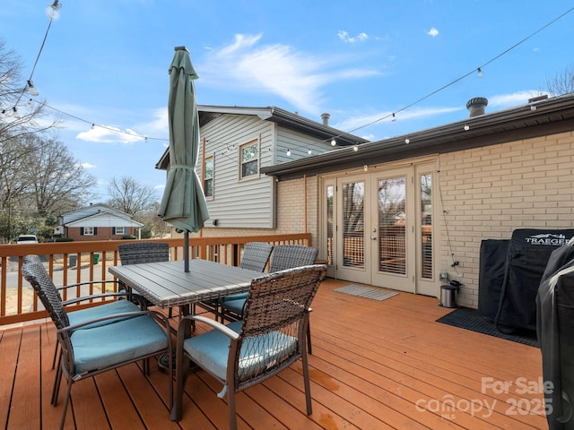 wooden deck featuring outdoor dining space and french doors