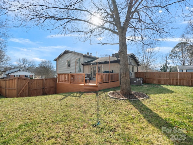 back of property with a wooden deck, a fenced backyard, a gate, a yard, and brick siding