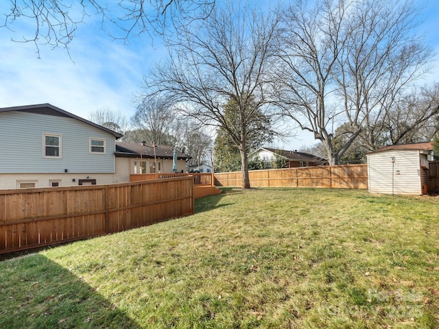 view of yard with an outbuilding, a shed, and a fenced backyard