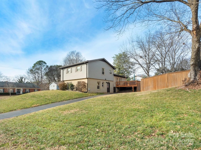 view of side of property featuring a yard, fence, a shed, an outdoor structure, and a wooden deck