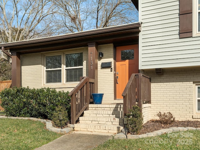 entrance to property featuring brick siding