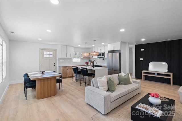 living room featuring sink and light wood-type flooring