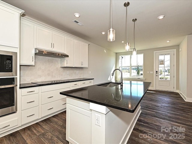 kitchen with sink, white cabinetry, a center island with sink, pendant lighting, and oven