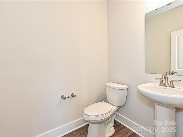 bathroom featuring wood-type flooring, sink, and toilet