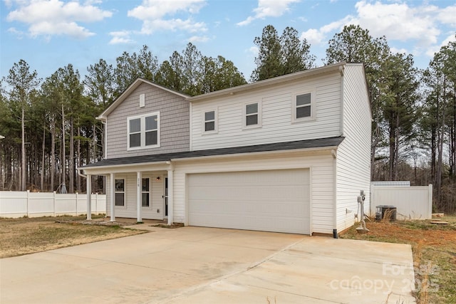 traditional-style home featuring a garage, fence, a porch, and concrete driveway