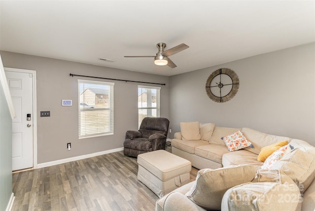 living room with visible vents, ceiling fan, baseboards, and wood finished floors