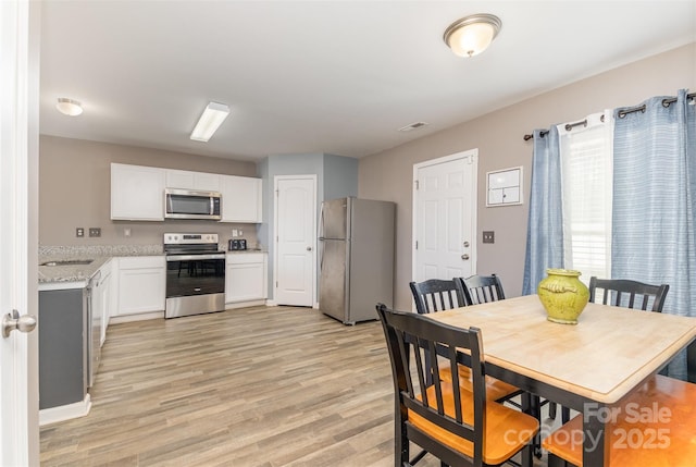 dining room with visible vents and light wood-style flooring