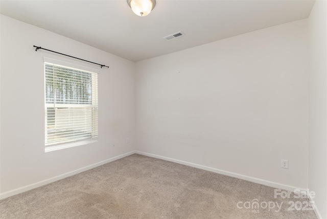 unfurnished room featuring carpet floors, visible vents, and baseboards