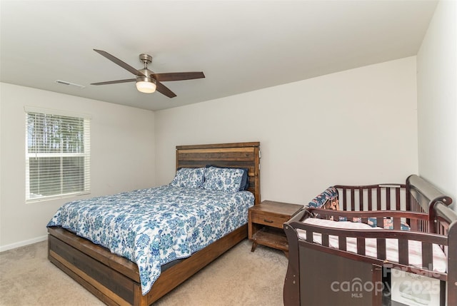 bedroom featuring ceiling fan, visible vents, baseboards, and light colored carpet