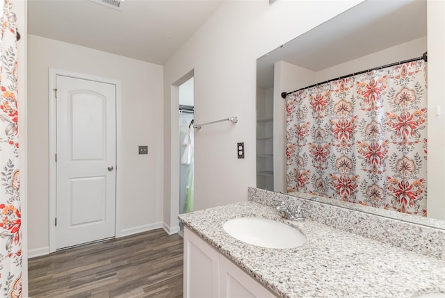 bathroom with vanity, baseboards, and wood finished floors