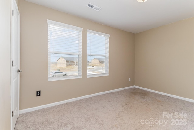spare room featuring baseboards, visible vents, and carpet flooring