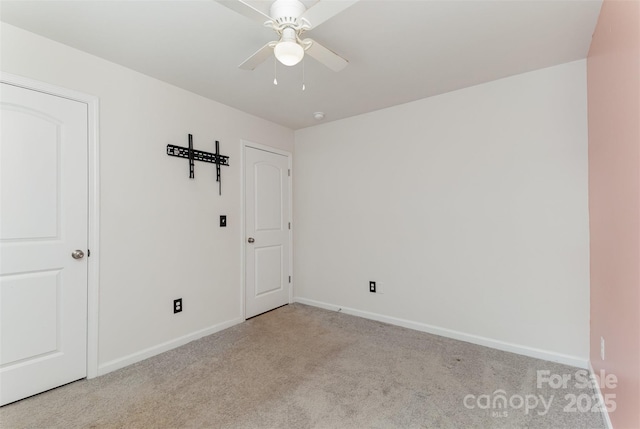 empty room with ceiling fan, baseboards, and light colored carpet