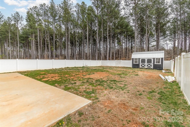 view of yard featuring a fenced backyard, an outdoor structure, a shed, and a patio
