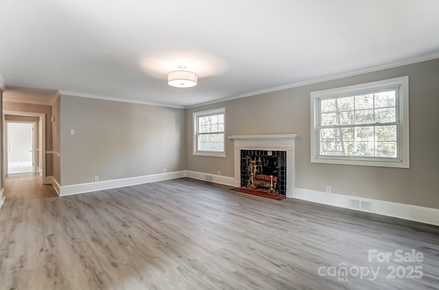 unfurnished living room with ornamental molding and light hardwood / wood-style flooring