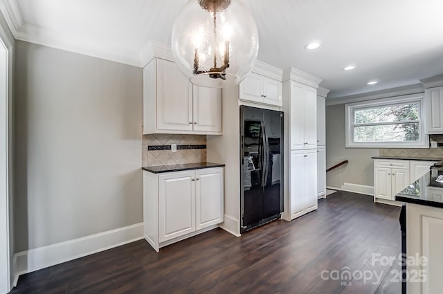 kitchen featuring white cabinetry, backsplash, dark hardwood / wood-style flooring, a notable chandelier, and black fridge