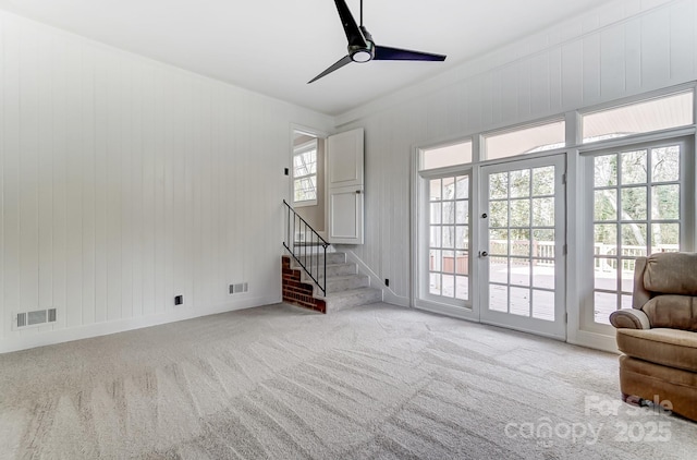 unfurnished living room featuring light carpet and ceiling fan