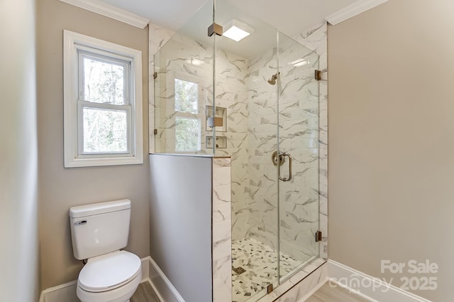 bathroom featuring a shower with shower door and toilet