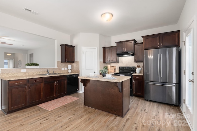 kitchen with sink, dark brown cabinets, black appliances, light hardwood / wood-style floors, and a kitchen island