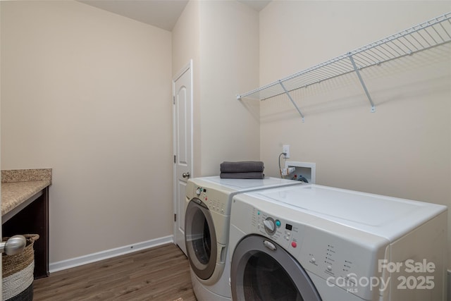 laundry area with dark hardwood / wood-style flooring and independent washer and dryer