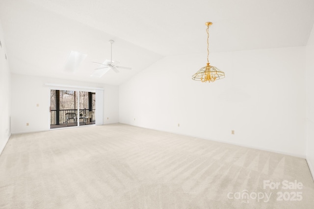 carpeted empty room with vaulted ceiling with skylight and ceiling fan