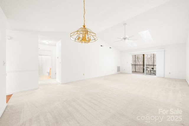 unfurnished room featuring light carpet, vaulted ceiling with skylight, visible vents, and ceiling fan with notable chandelier