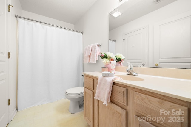 full bathroom with tile patterned floors, vanity, toilet, and a textured ceiling