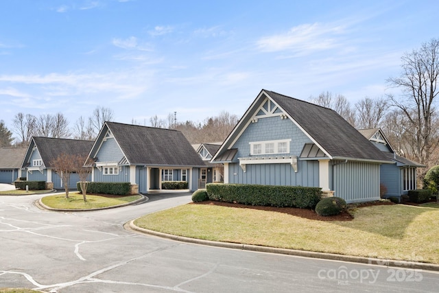 view of front of home featuring board and batten siding, a front yard, and concrete driveway