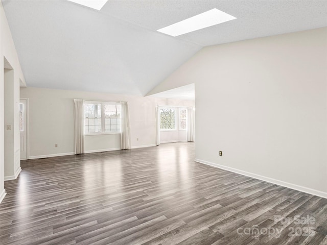 416 Hunters Glen Ln, Hendersonville, NC 28739 - unfurnished living room with baseboards, dark wood finished floors, and vaulted ceiling with skylight